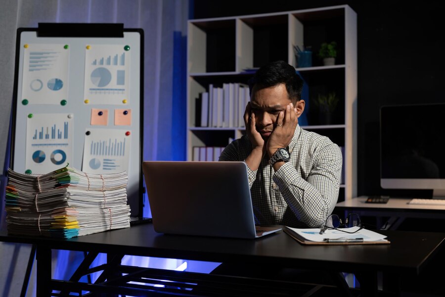 tired bored asian male worker sit desk need rest suffer from fatigue overworked office exhausted man working computer late night try meet deadline project 562687 1938 1