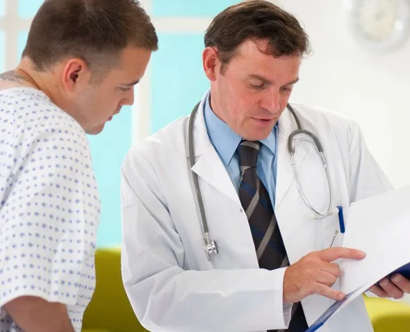 doctor goes over paper work with patient in exam room