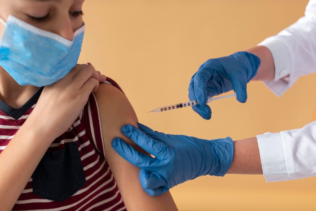 close up kid with mask getting vaccine 23 2148989348